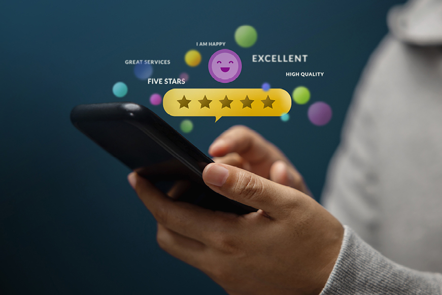 A person holding a phone with 5 stars above it and examples of feedback, like "Great services", "High quality", and "Excellent"