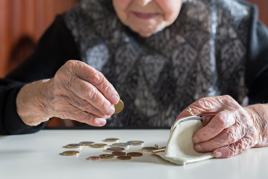 An Elderly Person Counting Coins From Their Purse