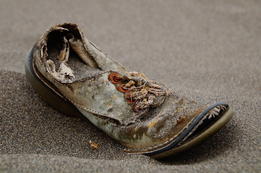 A shoe discarded in sand