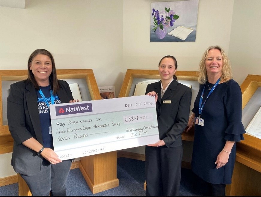 Three people holding a prop cheque