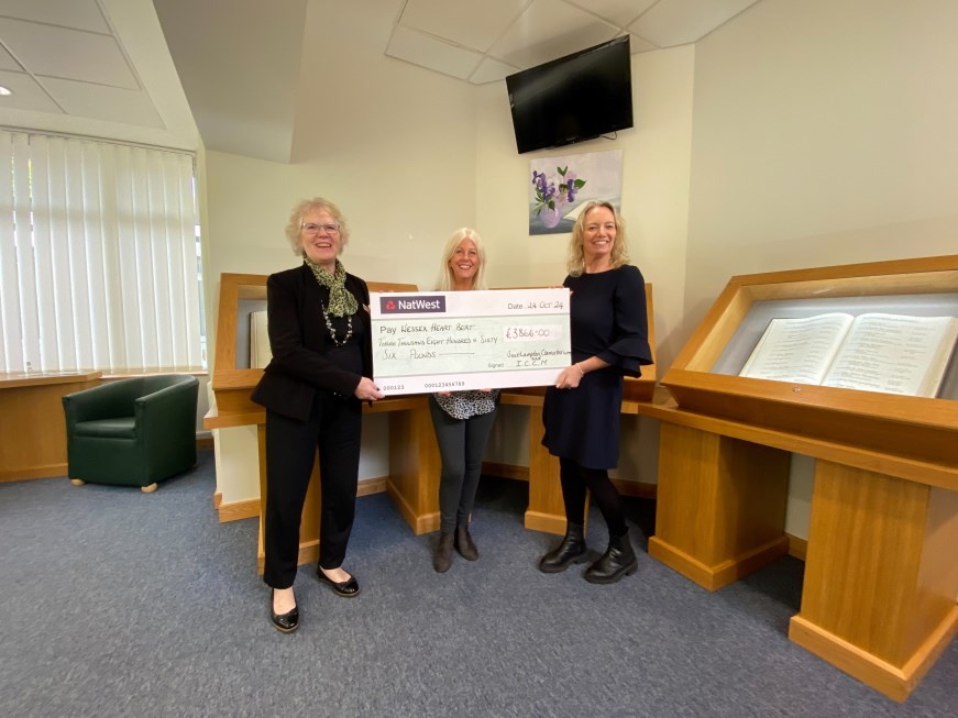 Three people holding a prop cheque