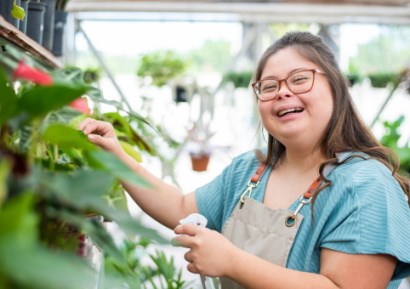 Young woman with Down's syndrome working in greenhouse