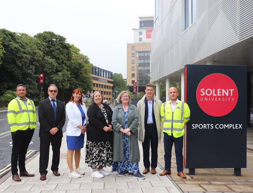 Councillors and partners standing beside a sign that says "Solent University Sports Complex"
