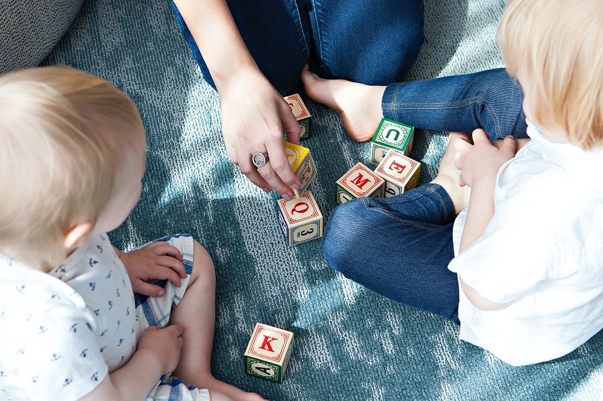 Children and an adult playing with blocks