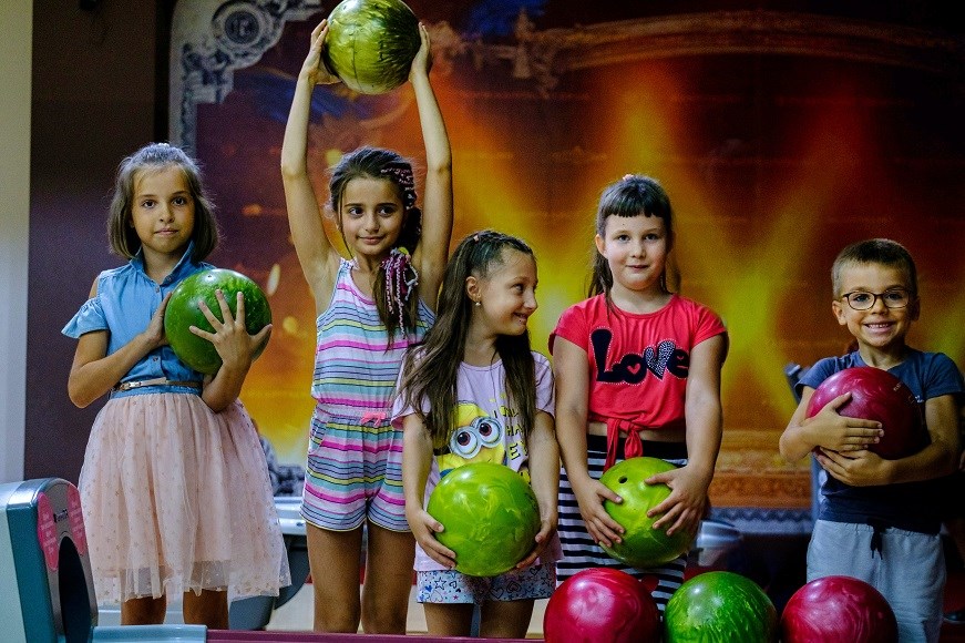 A group of children with colourful bowling balls
