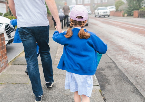 A man and a child walking to school