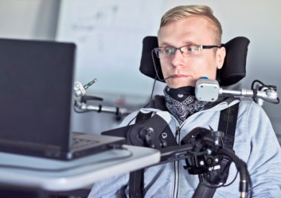 Disabled man using specialist equipment to operate computer