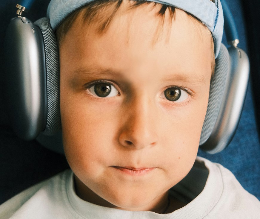 A young boy wearing large headphones