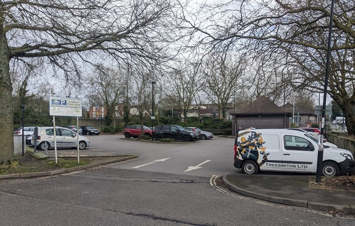 Image of car park entrance with white sign which says 'Collondales Car Park 2 hours maximum stay' with a blue parking symbol and Southampton City Council logo on the left. Cars and vans are parked in the car park and on the ground are two white arrows pointing in opposite directions, showing drivers to entrance and exit to the car parks