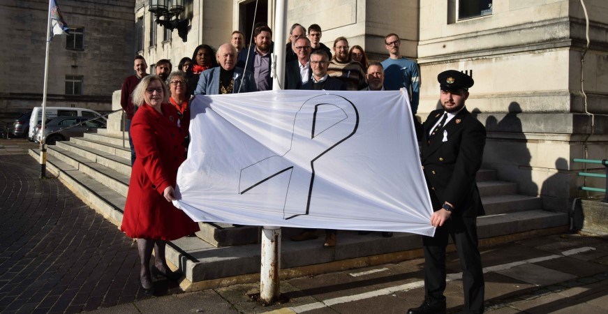 White Ribbon Day flag being held outside the Civic Centre