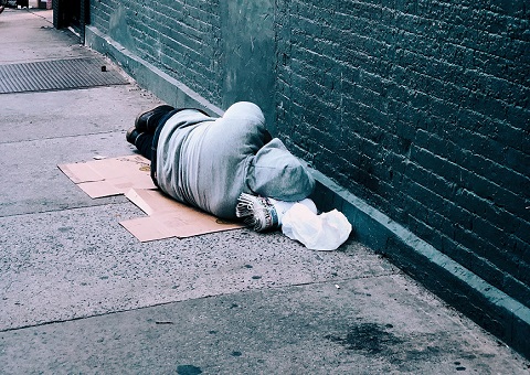 A homeless person asleep on the street